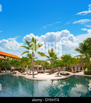 swimming pool surrounded by lush tropical plants amd palm trees Stock Photo