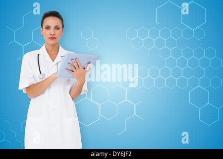 Composite image of pretty nurse using tablet pc Stock Photo