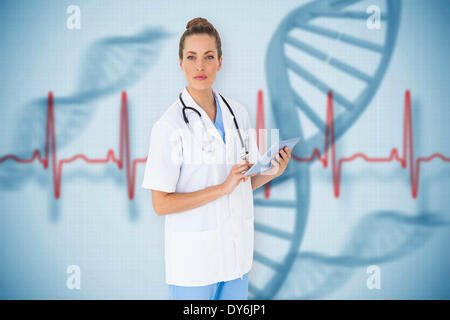 Composite image of pretty nurse using tablet pc Stock Photo
