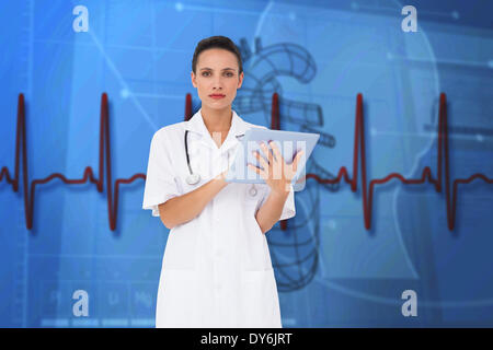 Composite image of pretty nurse using tablet pc Stock Photo