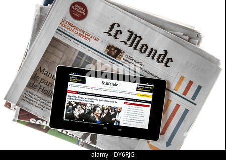 Touchscreen digital tablet showing online world news on top of French Le Monde newspaper on white background Stock Photo