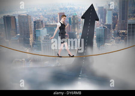 Composite image of businesswoman doing a balancing act Stock Photo