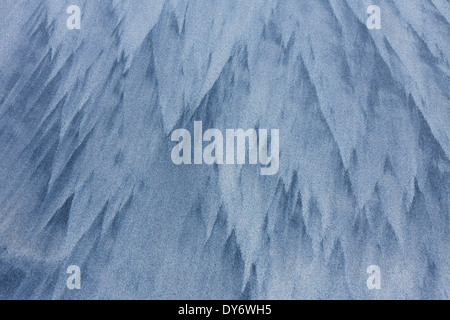 Abstract patterns in the sea sand from water erosion at beach along the coast in winter Stock Photo