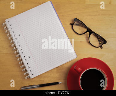 Overhead of notebook and glasses with pen and coffee cup Stock Photo