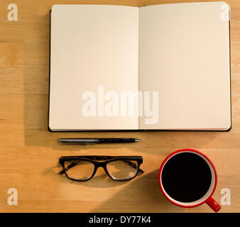 Overhead of open notebook with pen glasses and coffee Stock Photo