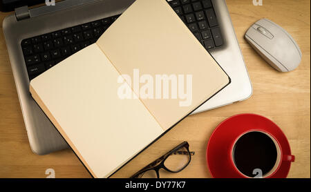 Overhead of open notebook on laptop Stock Photo