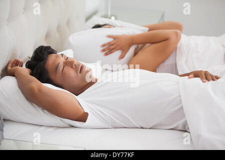 Woman covering her ears as partner is snoring loudly Stock Photo