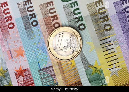 One Euro coin on several Euro banknotes Stock Photo