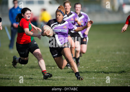 Aberystwyth university women (in red and green) playing rugby against Trinity St Davids university, Wales UK Stock Photo