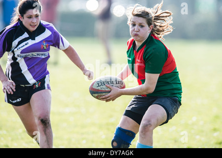 Aberystwyth university women (in red and green) playing rugby against Trinity St Davids university, Wales UK Stock Photo