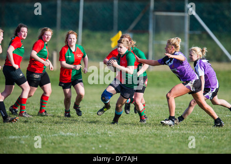 Aberystwyth university women (in red and green) playing rugby against Trinity St Davids university, Wales UK Stock Photo