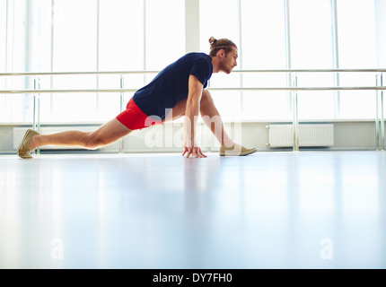 Portrait of young man doing physical exercise for stretching Stock Photo