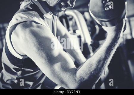 Arm of strong man doing exercise with barbell Stock Photo