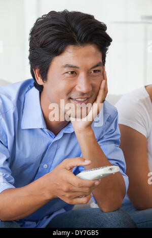 Happy man sitting on couch watching tv Stock Photo