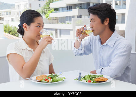 Happy couple having a meal together with white wine Stock Photo