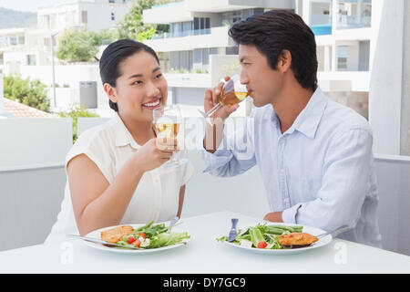 Happy couple having a meal together with white wine Stock Photo