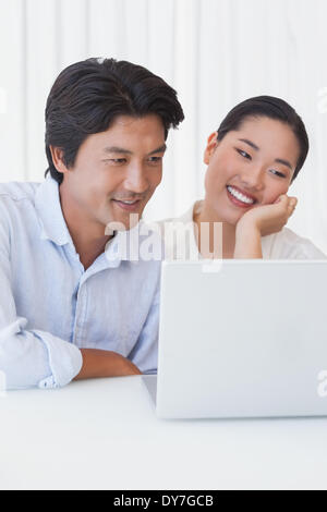 Happy couple using laptop together Stock Photo