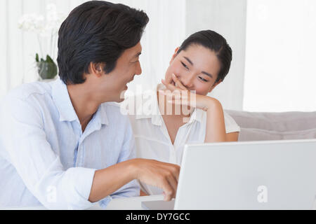 Happy couple using laptop together Stock Photo
