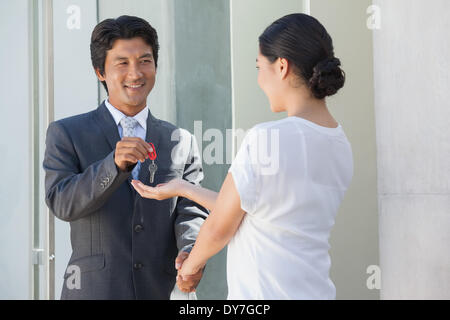 Smiling estate agent giving the key to buyer Stock Photo