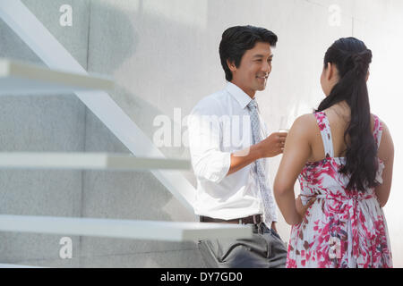 Man talking with his girlfriend wearing a floral dress Stock Photo