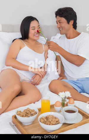 Happy couple having breakfast in bed Stock Photo