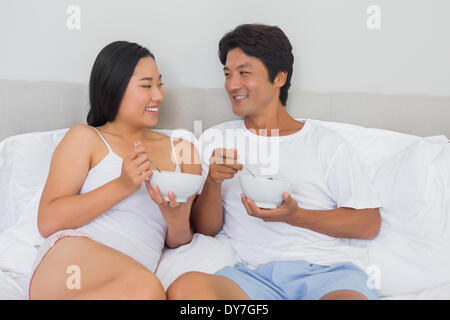 Happy couple having breakfast in bed Stock Photo