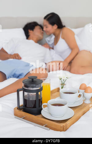 Affectionate couple having breakfast in bed Stock Photo