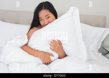 Smiling woman hugging her pillow Stock Photo