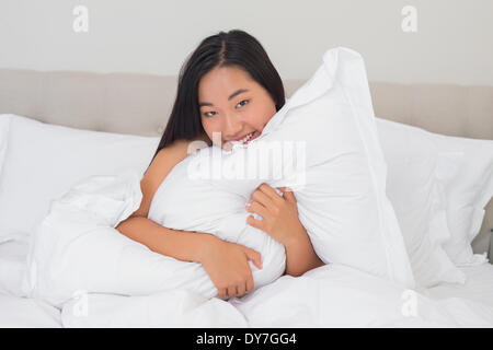 Smiling woman hugging her pillow Stock Photo
