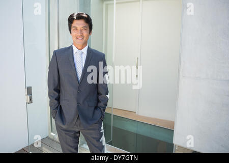 Confident estate agent standing at front door Stock Photo