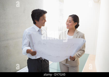 Estate agent looking at blueprint with potential buyer Stock Photo