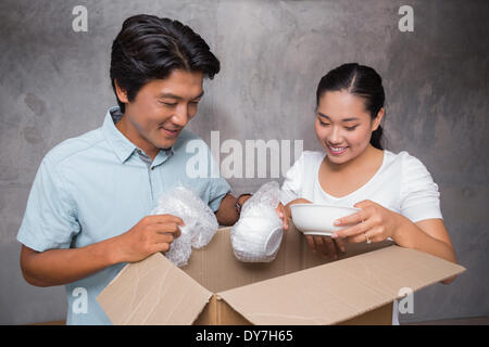 Happy couple unpacking moving boxes Stock Photo