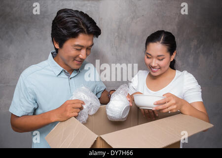 Happy couple unpacking moving boxes Stock Photo