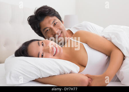 Smiling couple lying in bed Stock Photo
