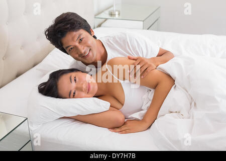 Smiling couple lying in bed Stock Photo