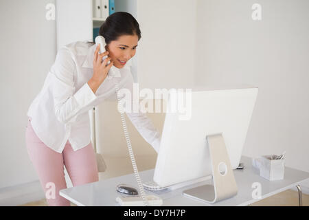 Casual businesswoman answering the phone Stock Photo