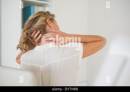 Casual businesswoman rubbing her neck Stock Photo