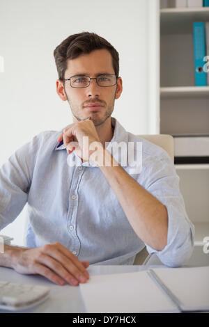 Casual businessman thinking at his desk Stock Photo
