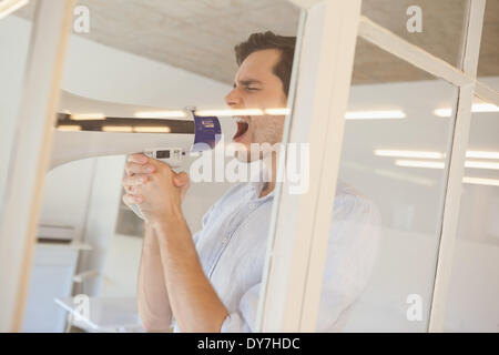 Casual businessman shouting through megaphone Stock Photo