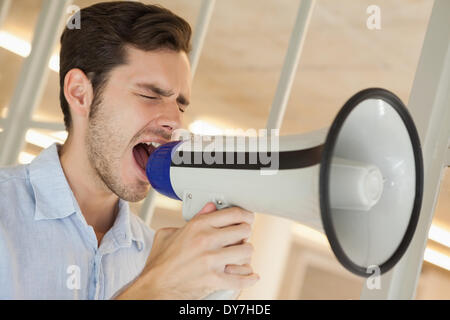 Casual businessman shouting through megaphone Stock Photo