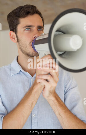 Casual businessman talking through megaphone Stock Photo