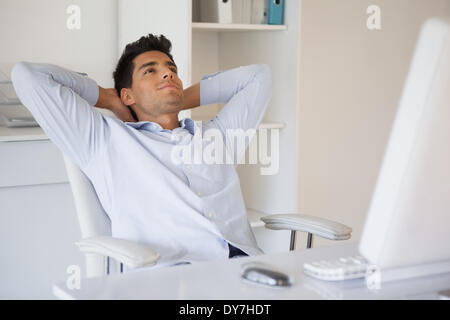 Casual businessman relaxing at desk leaning back Stock Photo