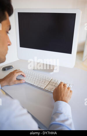 Businessman typing on keyboard at desk Stock Photo