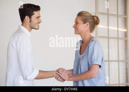 Casual business woman shaking hands with man Stock Photo