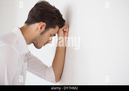 Casual businessman leaning against the wall Stock Photo