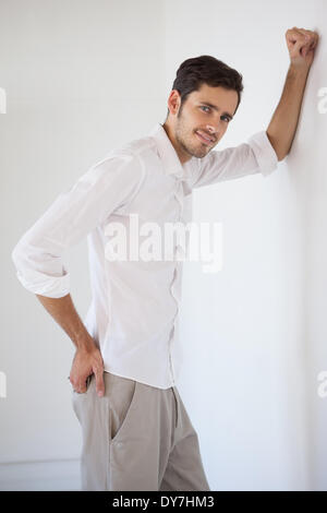 Casual businessman leaning against the wall Stock Photo