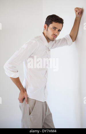 Casual businessman leaning against the wall Stock Photo