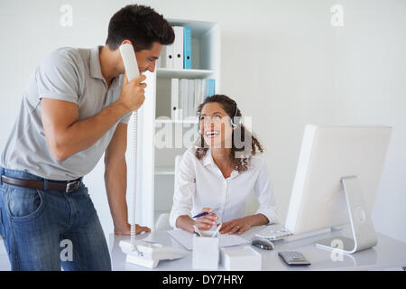 Casual business team laughing together at desk Stock Photo