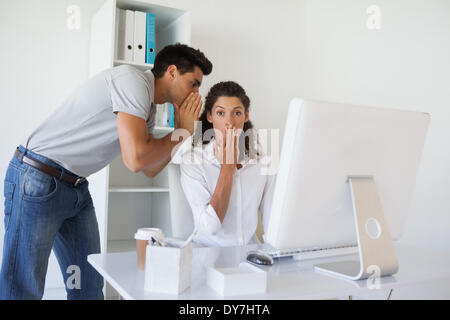 Casual business team gossiping at desk Stock Photo