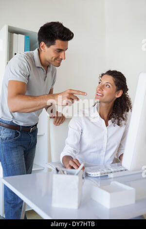 Casual business team smiling at each other at desk Stock Photo